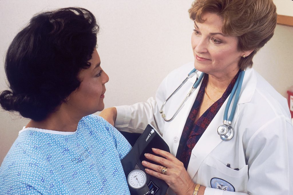 women normal blood pressure: A woman with a stethoscope talking to another woman